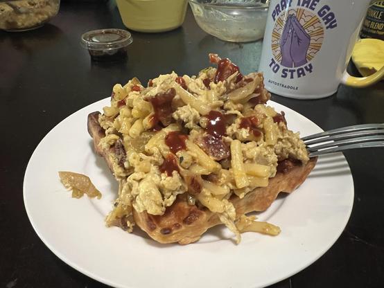 bacon, caramelized onion, green chili, eggs, and mac & cheese on top of a waffle then topped with our hot sauce

in the background the old Pray the Gay to Stay autostraddle coffee mug is visible along with so out of focus miscellany.