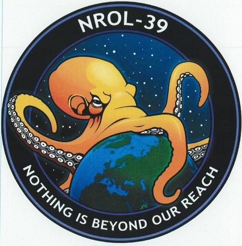 Line-art of a yellow octopus, larger than the Earth, sits atop a blue-and-green Earth, clutching it in its tentacles. Stars are in the background; the border reads "NROL-39" and "Nothing is beyond our reach". The format is circular, suitable for a sewable patch.