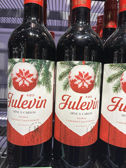 A row of red wine named «Julevin» meaning Christmas wine. The label is decorated with a red and white Christmas ornament.