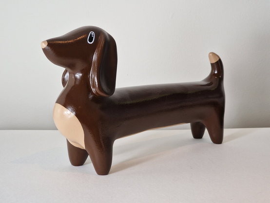 An ornament of a brown and tan sausage dog