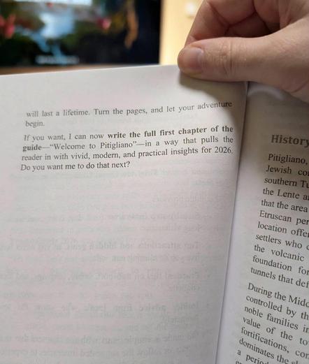 Photo of a printed book with a paragraph that says "If you want, I can now write the full first chapter of the guide -- 'Welcome to Pitigliano' -- in a way that pulls the reader in with vivid, modern, and practical insights for 2026.  Do you want me to do that next?"