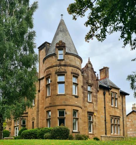 A large blonde sandstone Victorian Scots Renaissance style villa.