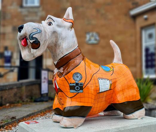 A large sculpture of a Scottie dog decorated to look like Sherlock Holmes.
