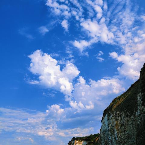 Nuages épars sur une falaise.