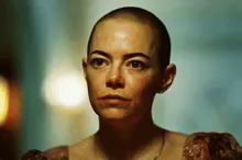 a woman with a shaved head is wearing a dress