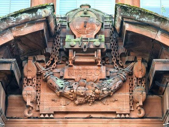 A relief sculprure of a steam locomotive on an Edwardian industrial building.
