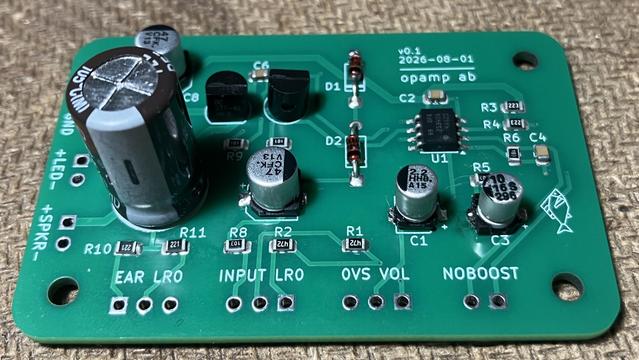 Small green circuit board with various components, including four surface-mounted electrolytic capacitors.