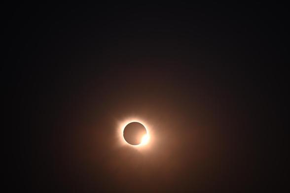 Foto des Endes der totalen Phase der Sonnenfinsternis, rechts ist ein hell leuchtender Punkt und um den Mond sieht ma einen hellen Ring.