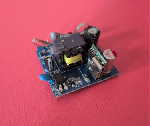 Photo of a blue PCB with some soldered-on components: Capacitors, transistors, and a USB-C adapter board