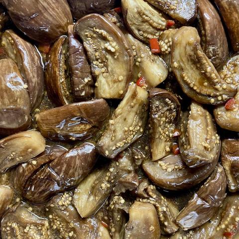 A pan of small aubergines, braised in soy, sake and sesame oil