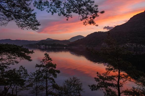 Pink / red sky reflected in a still sea.