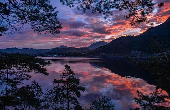 Sunrise over a still loch.