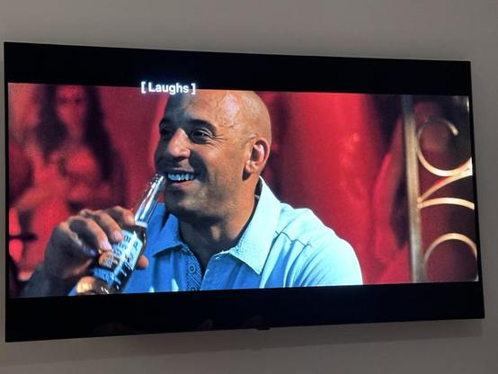 A screenshot of Vin Diesel drinking a Corona and laughing
