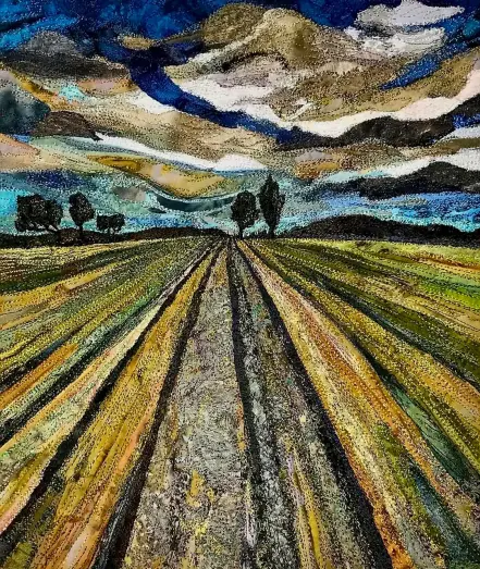 Pictorial textile artwork featuring a landscape of a field with treeline in the distance under a dramtic sky