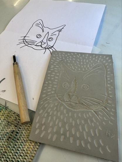 A carved lino block with a cat on it