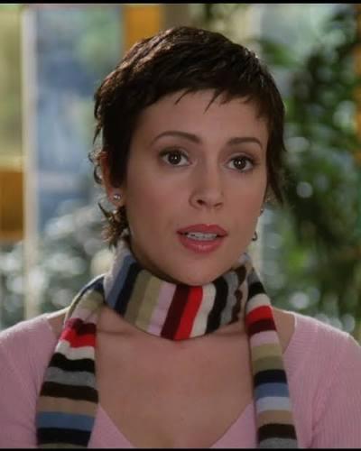 alyssa milano as phoebe halliwell in a white pink sweater and a very 00s stripy skinny scarf with a perfect pixie cut