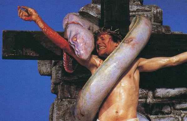 Jésus en croix, le bras droit mordu par un ver blanc géant