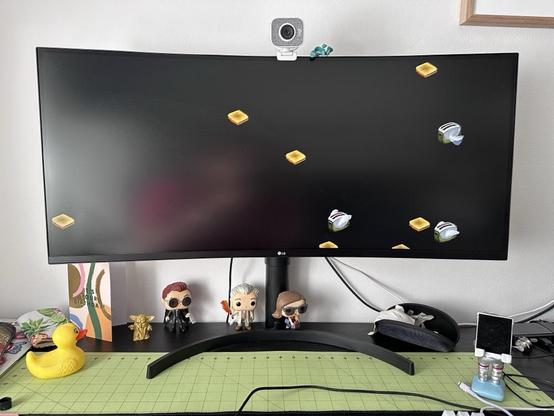 A photo of a widescreen computer monitor running the classic After Dark "Flying Toasters" screensaver