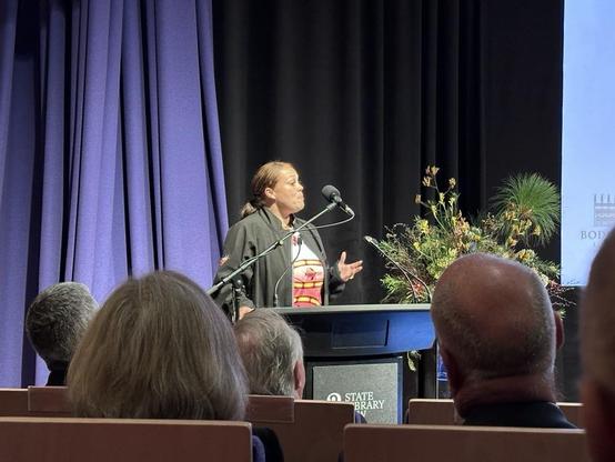 A First Nations woman presenting at a lectern