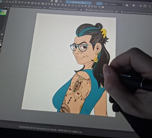 Foto von mir am Huion Zeichembildschirm. Zu sehen eine flat kolorierte weibliche Figur in Büstenansicht. Weiß, braune, mittellamge Haare mit tpekisen und grauen Strähnen, türkiser Brille und Tätowierungen aif dem Arm.