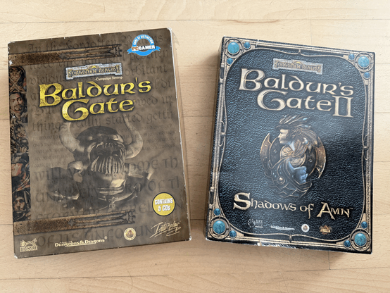Picture shows the game boxes of Baldur's Gate and Baldur's Gate II on a wooden background.