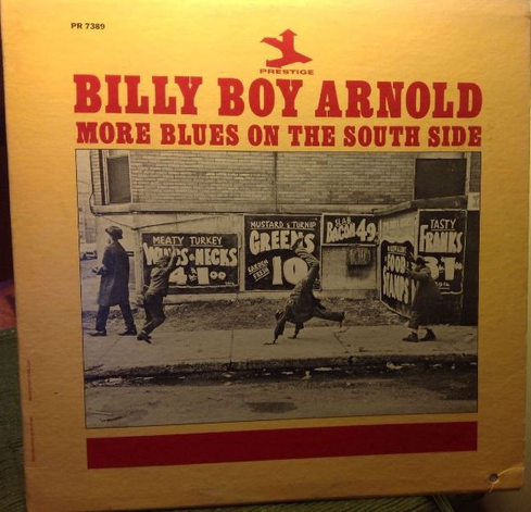 Album cover for Billy Boy Arnold’s More Blues on the South Side on Prestige Records. The yellow cover features large red lettering above a black-and-white street photograph of people walking past a brick wall covered with hand-painted food advertisements.