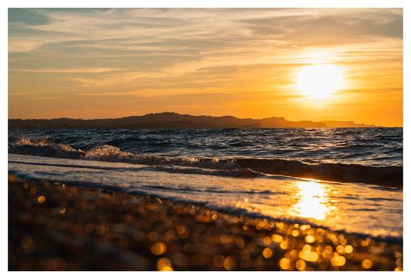 Strand, Wolken, Glitzer, geschichtete Berge.