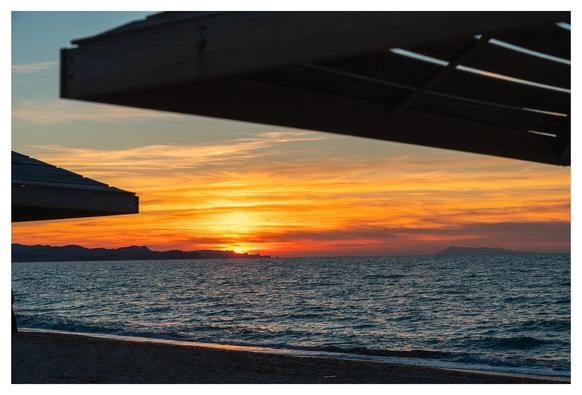 Sonnenuntergang zwischen Sonnenschirmen.