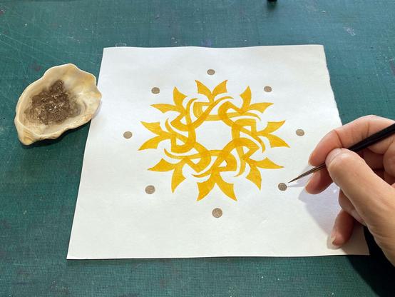 A finished print having its dots painted over with white shell gold.
