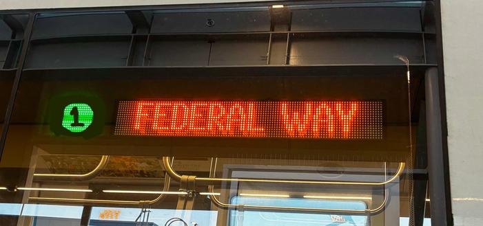 The LED display on the Seattle light rail, it’s been edited to have a green circle with the number “1” on it. The line number is next to a “federal way” label.