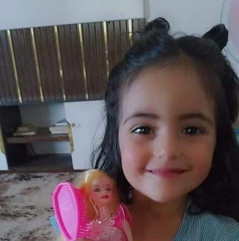 A child holds a small toy in a house in Gaza