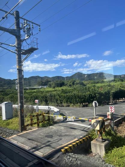 Train crossing near Toyohashi with blue sky and green farms