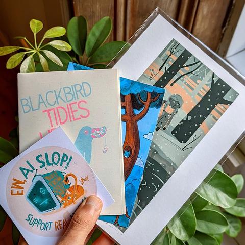 A hand holding an anti-ai-sicker, a zine, a postcard and a small print wrapped in compostable foil in front of a plant.