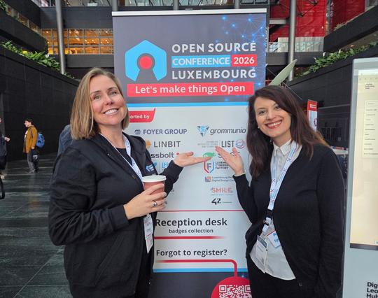 Elena and I in front of a poster at the Open Source Conference Luxembourg