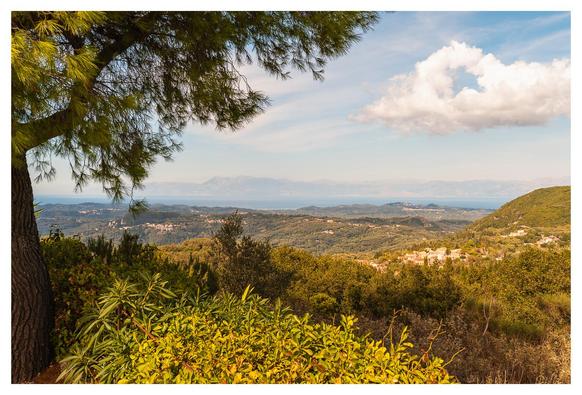 Blick in die Landschaft. Links ein Baum, rechts Berge, weiter vorne das Mittelmeer.