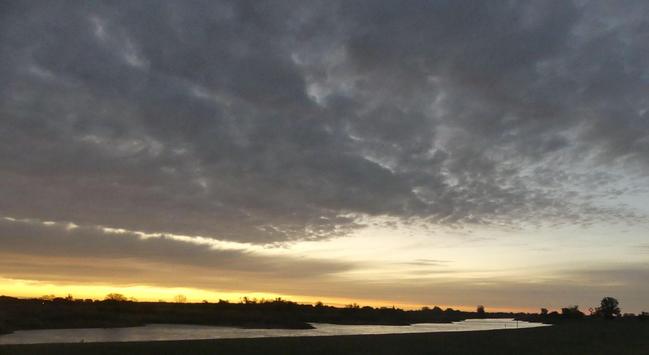 ein langes Stück Elbe, ein Stück klarer Himmel, darunter schiebt sich eine dünne Wolkendecke heran, es gibt einen gelben Streifen, der den Sonnenaufgang ankündigt, noch spiegelt sich das Ende der Nacht im Fluss