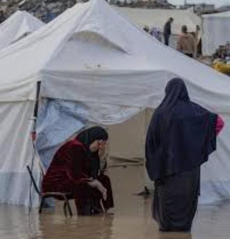 Two women in a tent covered with rainwater