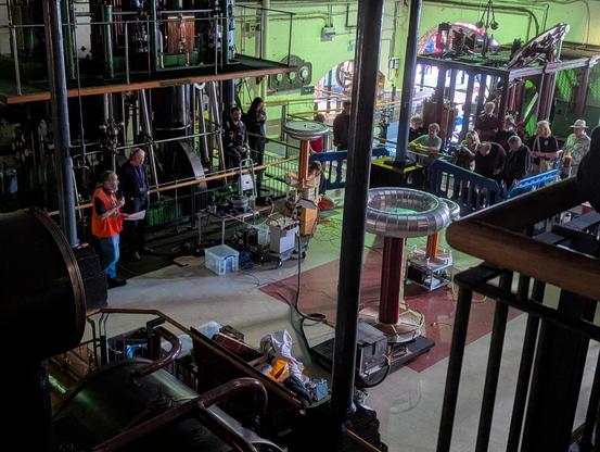 View of the main Tesla coil area from a balcony above. @ExtElec is giving a safety talk and telling people with pacemakers to keep their distance.