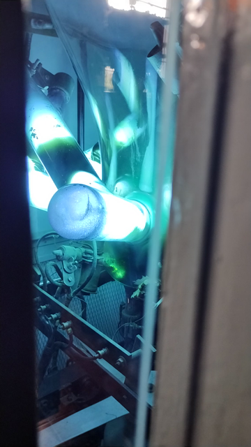 a glass bulb-shaped thing, overall about 1m high, with 20cm tube-shapes coming out of the bottom, glowing brightly aqua colour and there is a small pool of mercury at the bottom, where green sparks dance around excitedly. There is terrible background chatter noises on this.