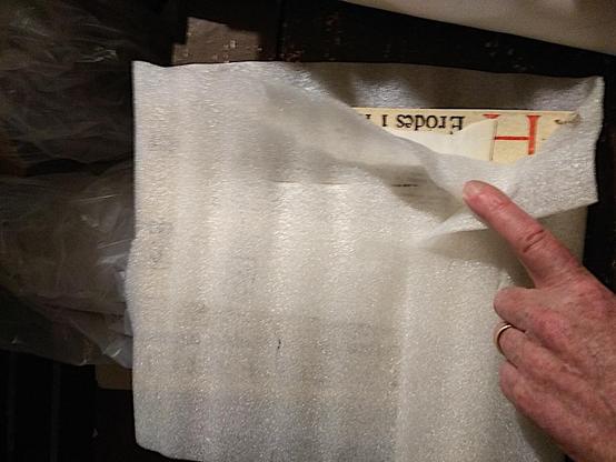 Peeling back the translucent plastic to show the book inside