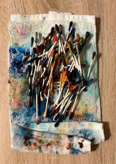 Photo shows two metric poop tons of used cotton swabs, resting on a heavily stained white cotton beach, in the middle of a wooden ocean. I should point out that the cotton swabs were dipped in fountain pen ink, and were definitely not used to clean unicorn ears.