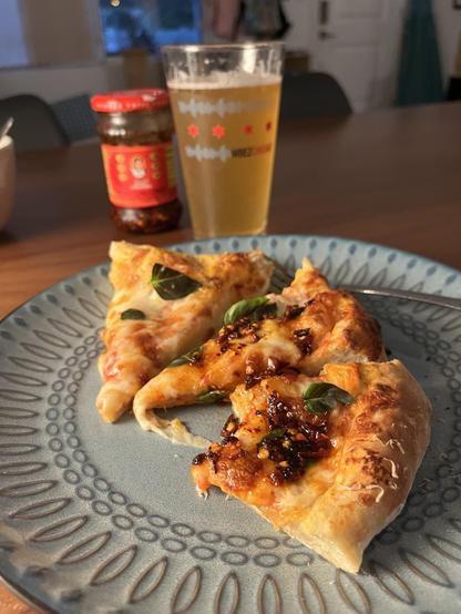 homemade pizza: cheese, basil, chili crisp. a cream ale in a wbez chicago pint glass