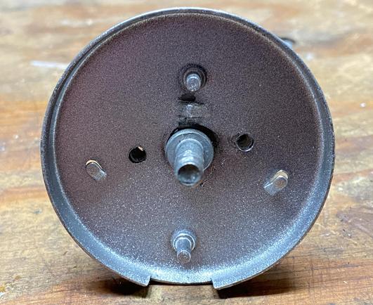 The de-rusted metal base, spraypainted with silver stop-rust, with two new holes that go through all the new parts of the bell, one on each side of the central threaded shaft that holds the actual bell itself.