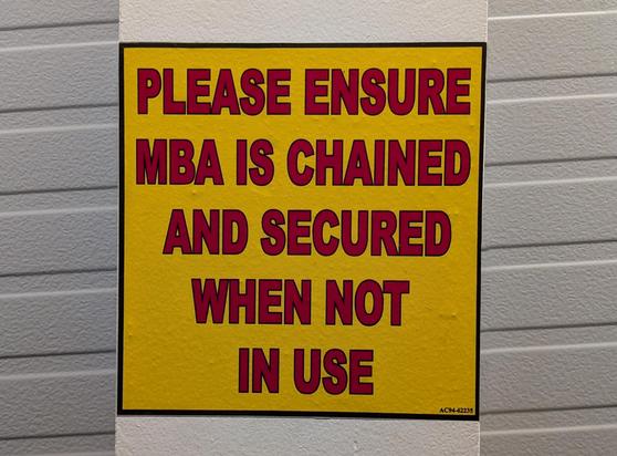 A sign reading "Please ensure MBA is chained and secured when not in use" taken on a jetway, Pearson Airport, Toronto, Ontario, Canada