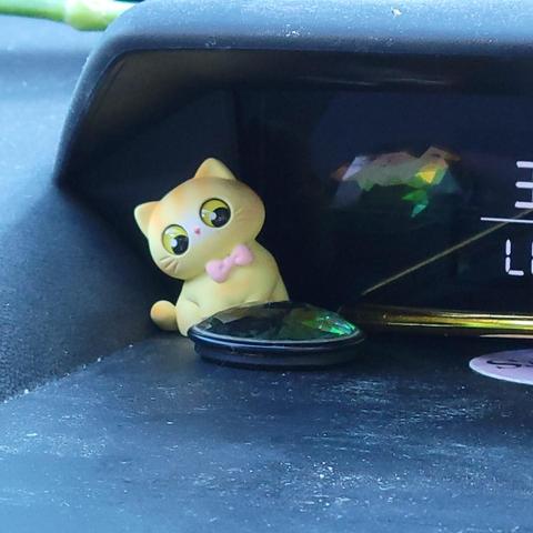 A tiny cat toy leaning back and staring into a cut gem, as if recoiling in horror.