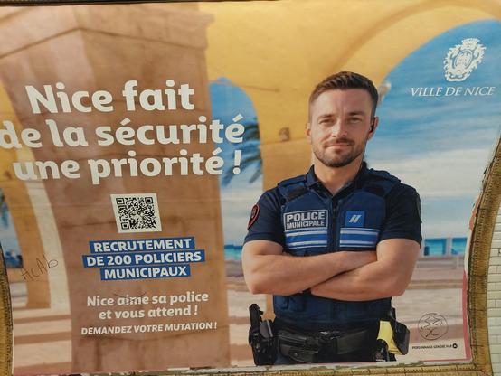Grande affiche de métro 4 par 3
un flic généré par IA, en manches courtes bras croisée, sur fond d'arcades et de promenade
Nice fait de la sécurité une priorité
Recrutement de 200 policiers municipaux
Nice aime sa police et vous attends, demandez votre mutation 
Un stylo a barré le "aime" et ajouté : ACAB