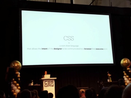 Elika in front of a screen with text:

CSS
is
a style sheet language
that allows the intent of the designer to be communicated to a browser that executes on it