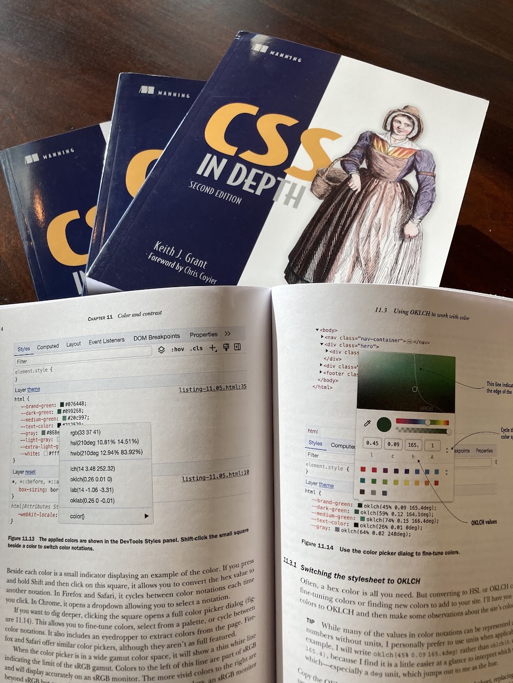 Several copies of CSS in Depth second edition. One is opened up to a page on working with OKLCH color, showing graphics printed in color