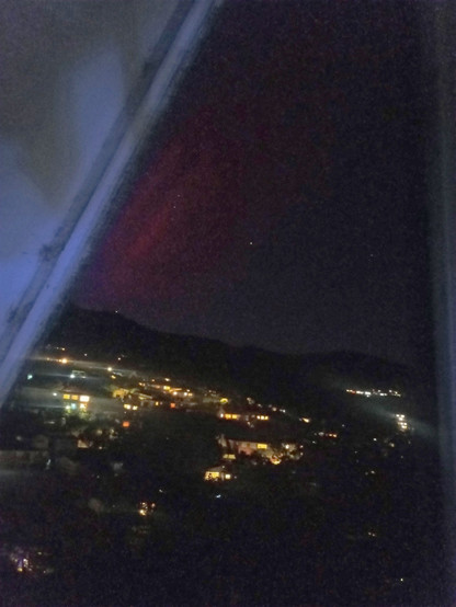 Very faint image of Aurora Australis following the slope of my roof behind our local hill.
