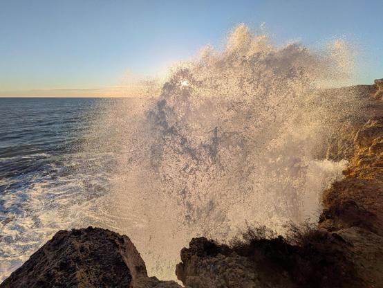 Waves breaking over the cliffs in Tarragona during sunset